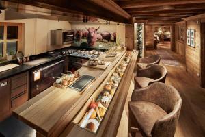 a large kitchen with a long table and chairs at Burg Vital Resort in Lech am Arlberg