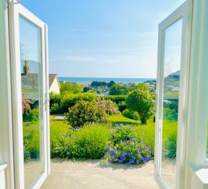 Gordy Hall -Sea facing Welsh cottage with stunning views في بينداين: نافذة مفتوحة مطلة على حديقة