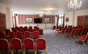 a conference room with red chairs and a flat screen tv at Bell by Greene King Inns in Thetford