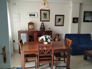sala de estar con mesa y sofá azul en Homely Apartments Blue Coast, en San Miguel de Salinas