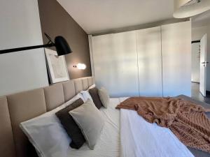 a bedroom with a large bed with white sheets and pillows at Bielawy Suite in Bydgoszcz +7 photos