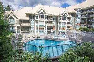 een appartementencomplex met een zwembad voor een gebouw bij Woodrun 208 - Ski In Ski Out, Common Area Hot Tub & Pool, Fireplace in Whistler