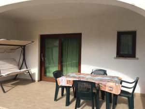 a table and chairs in a room with a bed at Casa Vacanza Budoni Mare in Budoni
