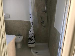 a bathroom with a shower and a toilet with towels at Casa Vacanza Budoni Mare in Budoni