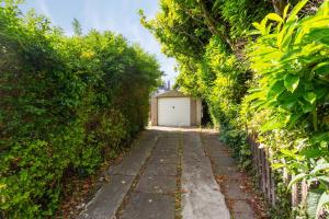 Lovely 3bed House-Private parking في إدنبرة: مسار حديقة مع مرآب في المسافة
