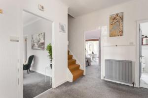 Lovely 3bed House-Private parking في إدنبرة: ممر أبيض مع درج في المنزل
