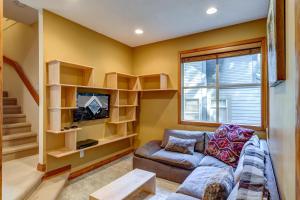 Una sala de estar con un sofá y un televisor. en Snowy Creek 14, en Whistler
