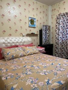 a bedroom with a bed with a flowery wallpaper at Cameron Highlands Muslim Apartment by AziziCameron in Cameron Highlands