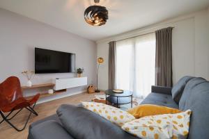 a living room with a blue couch and a tv at Apartman Babalui in Trogir