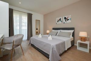 a bedroom with a large bed and a chair at Apartman Babalui in Trogir