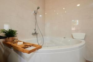 a white bathroom with a tub and a shower at Apartman Babalui in Trogir +34 photos