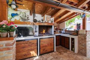 an outdoor kitchen with a fireplace in the middle at Apartman Babalui in Trogir