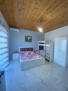 - une chambre avec un lit et un plafond en bois dans l'établissement Vila Rafael, à Saranda