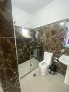 La salle de bains est pourvue de toilettes, d'une douche et d'un lavabo. dans l'établissement Vila Rafael, à Saranda