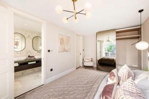a bedroom with a bed and a bathroom with a sink at Ultra Luxury Central London 3Bed Apartment in London