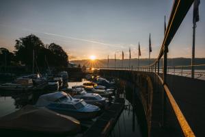 eine Gruppe von Booten, die bei Sonnenuntergang in einem Yachthafen angedockt sind in der Unterkunft Hotel Lindauer Hof in Lindau