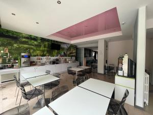 una habitación con mesas y sillas y una cocina en Grand Hôtel Niort Centre en Niort