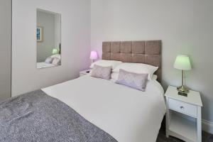a bedroom with a large white bed and a mirror at Host & Stay - Brooklands Timeless in Scarborough