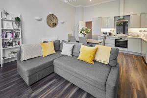 a living room with a gray couch with yellow pillows at Host & Stay - Brooklands Timeless in Scarborough