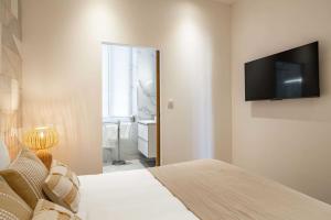 Schlafzimmer mit einem Bett und einem Flachbild-TV in der Unterkunft Cosy flat 100m from the beach - Carré d'Or - 1BR2p in Cannes