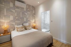 ein Schlafzimmer mit einem großen Bett und einer Steinmauer in der Unterkunft Cosy flat 100m from the beach - Carré d'Or - 1BR2p in Cannes