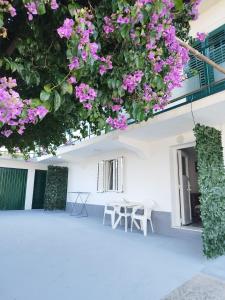 a patio with pink flowers hanging from a building at Apartment Filip in Trogir