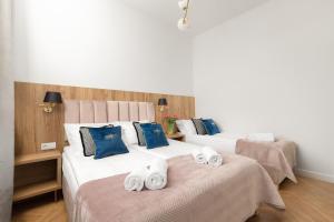2 camas en una habitación de hotel con toallas en las camas en Movo II Old Town Apartments en Varsovia