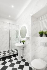 a white bathroom with a sink and a mirror at Movo II Old Town Apartments in Warsaw