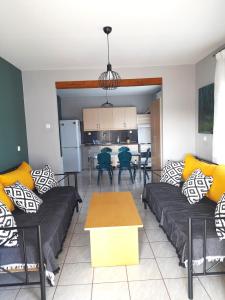 a living room with two couches and a kitchen at villa Narkissos - Καναλάκι - Εξοχική κατοικία in Nárkissos