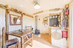 cocina con mesa de madera y encimera en Littlestock Shepherds Hut en Shipton under Wychwood