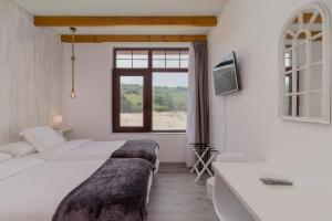 1 dormitorio con 2 camas y ventana en Hotel SanMar, en Cóbreces