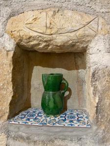 eine grüne Vase auf einer Steinmauer in der Unterkunft Masseria Usamborgia in Noto