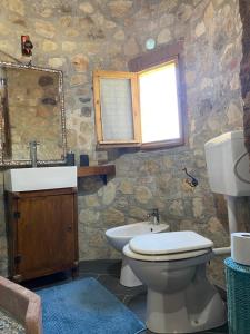 a bathroom with a toilet and a sink and a mirror at Masseria Usamborgia in Noto