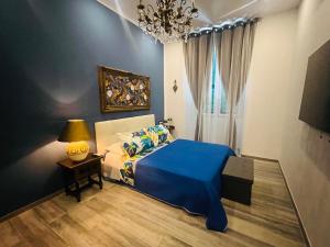 a bedroom with a blue bed and a chandelier at Casa Vacanza Ginevra in Genoa