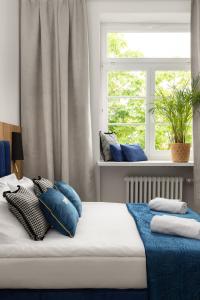 Un dormitorio con una cama con almohadas azules y una ventana en Movo II Old Town Apartments en Varsovia