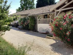 una casa con un banco y flores en el patio en Phèdre en Saône, en Genouilleux
