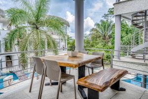 a patio with a wooden table and chairs on a balcony at Hermosa Waves D2 in Playa Hermosa