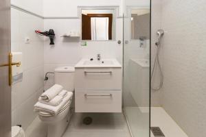 a bathroom with a toilet and a sink and a shower at Hotel SanMar in Cóbreces