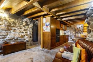 a living room with a couch and a stone wall at Isatour Casa na Serra in Adsamo