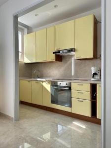 a kitchen with yellow cabinets and a stove top oven at Il Blu di Laveno in Laveno