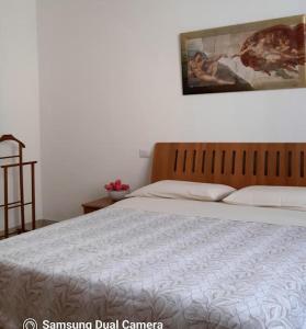 a bed in a bedroom with a picture on the wall at Il Blu di Laveno in Laveno