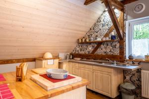 una cocina con armarios de madera y un lavabo en una cabaña en Agroturystyka Ziemia Obiecana, en Nielestno
