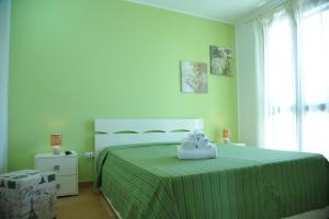 a bedroom with a bed with a green bedspread at B&B Erminia - Free Parking e Mare Vicino in Presicce