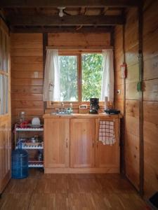 a kitchen with a sink and a window in a cabin at Charming cabin surrounded by nature in El Escudero