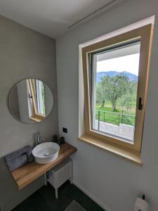 baño con lavabo y ventana en Olivo Luxury Apartments, en Malcesine
