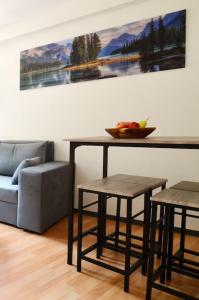 sala de estar con mesa, taburetes y sofá en Ferienwohnung Ivanka mit Garten, en Schliersee