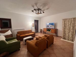 a living room with couches and a flat screen tv at Casa Michela in Caporciano