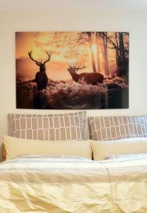 una foto de dos ciervos en una pared sobre una cama en Ferienwohnung Ivanka mit Garten en Schliersee