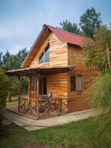 a log cabin with a table in front of it at Charming cabin surrounded by nature in El Escudero
