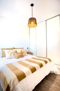 a bedroom with a large bed and a pendant light at ALQUILERES TEMPORARIOS MADRYN in Puerto Madryn